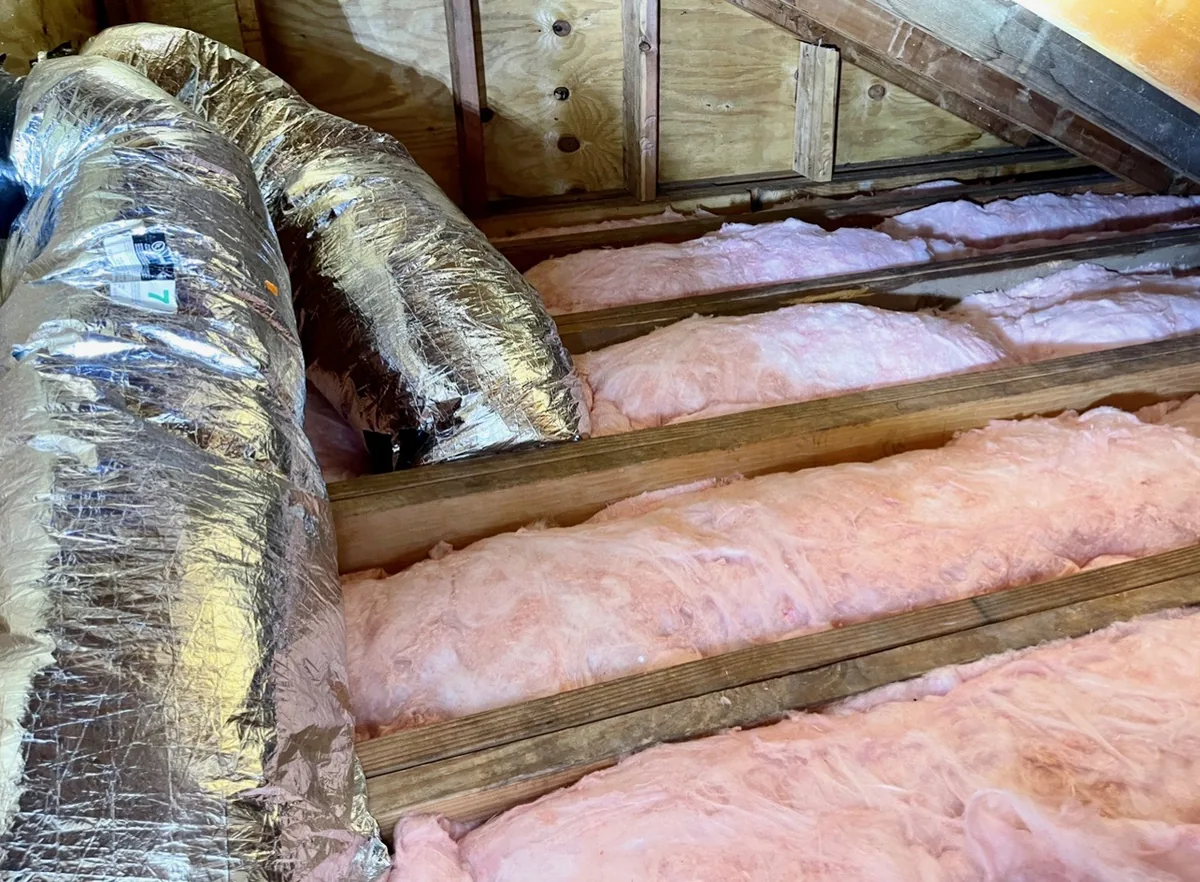 Attic restored with fresh insulation and repaired ductwork