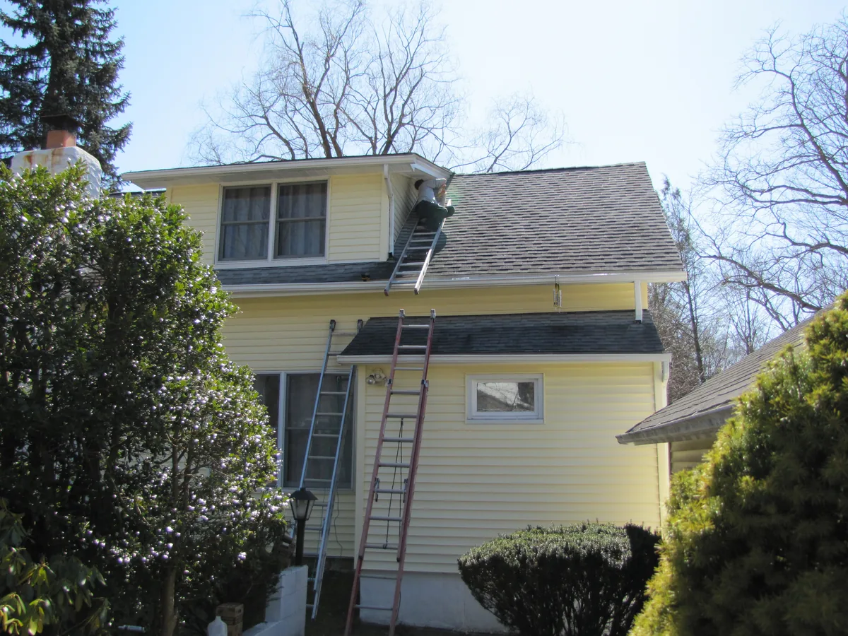 Technician sealing soffit and return points of dormer windows to stop flying squirrels