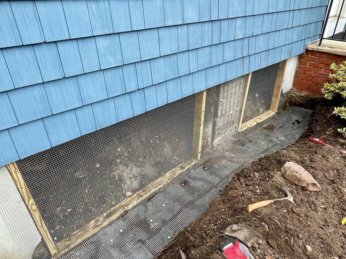 Heavy wire mesh fastened over the framing to seal out wildlife and covering bottom of trench
