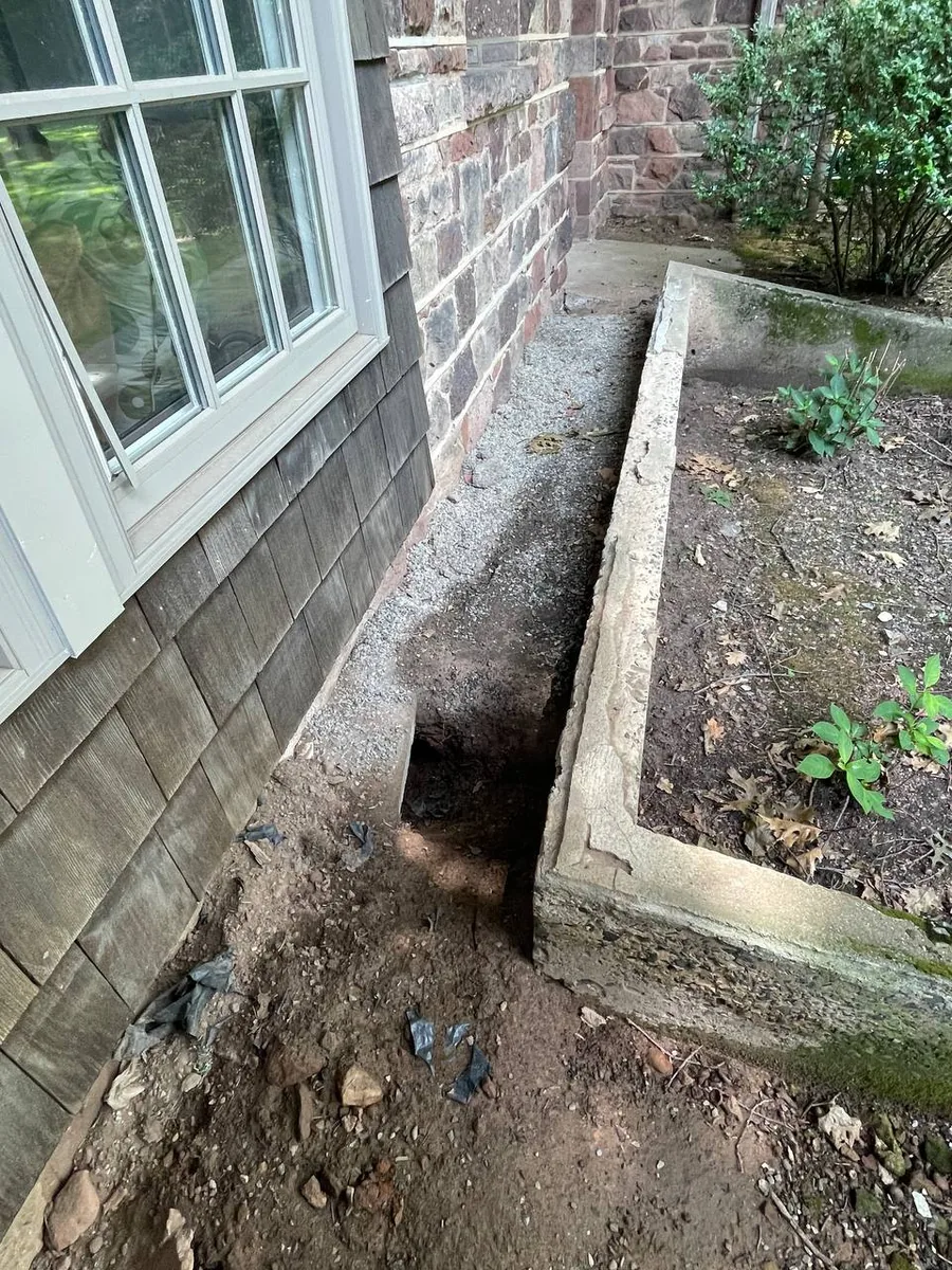Groundhog burrow dug next to a house